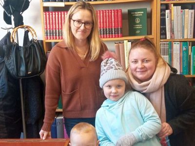 Uczestniczka akcji "Mała książka Wielki człowiek" z mamą i bratem oraz bibliotekarzem z Gminnej Biblioteki Publicznej w Malechowie. 