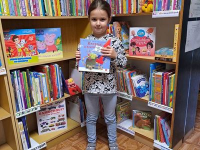 Uczestniczka akcji "Mała książka Wielki człowiek" pozuje z książeczkami. 