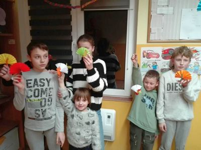 Dzieci z Placówki Wsparcia Dziennego w Podgórkach pozują z papierowymi ozdobami.