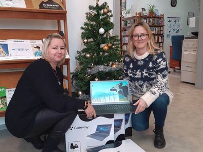 Pracownice Gminnej Biblioteki Publicznej w Malechowie prezentują laptopa.