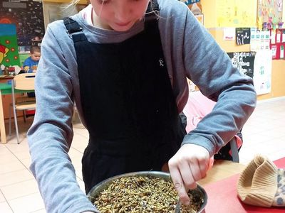 Wychowanka z Placówki Wsparcia Dziennego z Lasek miesza ziarna ze smalcem.