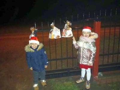 Dzieci z Karwic przy płocie, podziwiają zawieszone paczki.