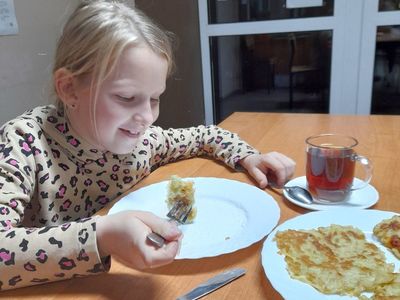 Dziewczynka z Placówki Wsparcia Dziennego w Sulechowie podczas jedzenia placków ziemniaczanych.