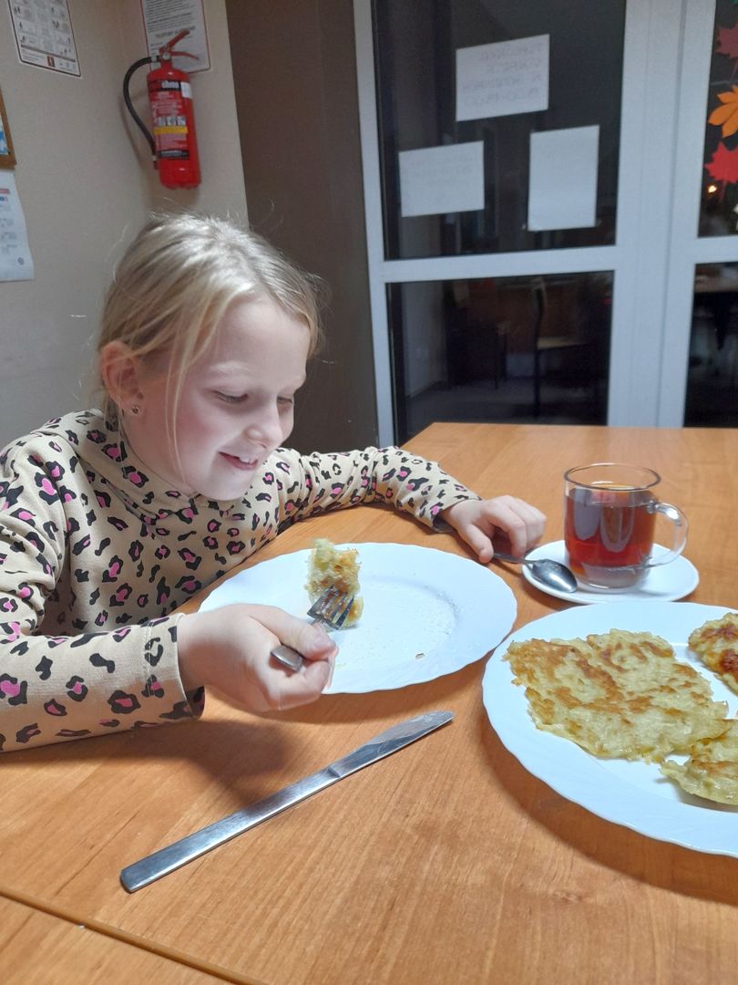 Dziewczynka z Placówki Wsparcia Dziennego w Sulechowie podczas jedzenia placków ziemniaczanych. 