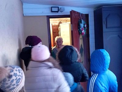 Dzieci z PWD z Lasek wręczają seniorowi prezent w postaci gipsowego anioła. 