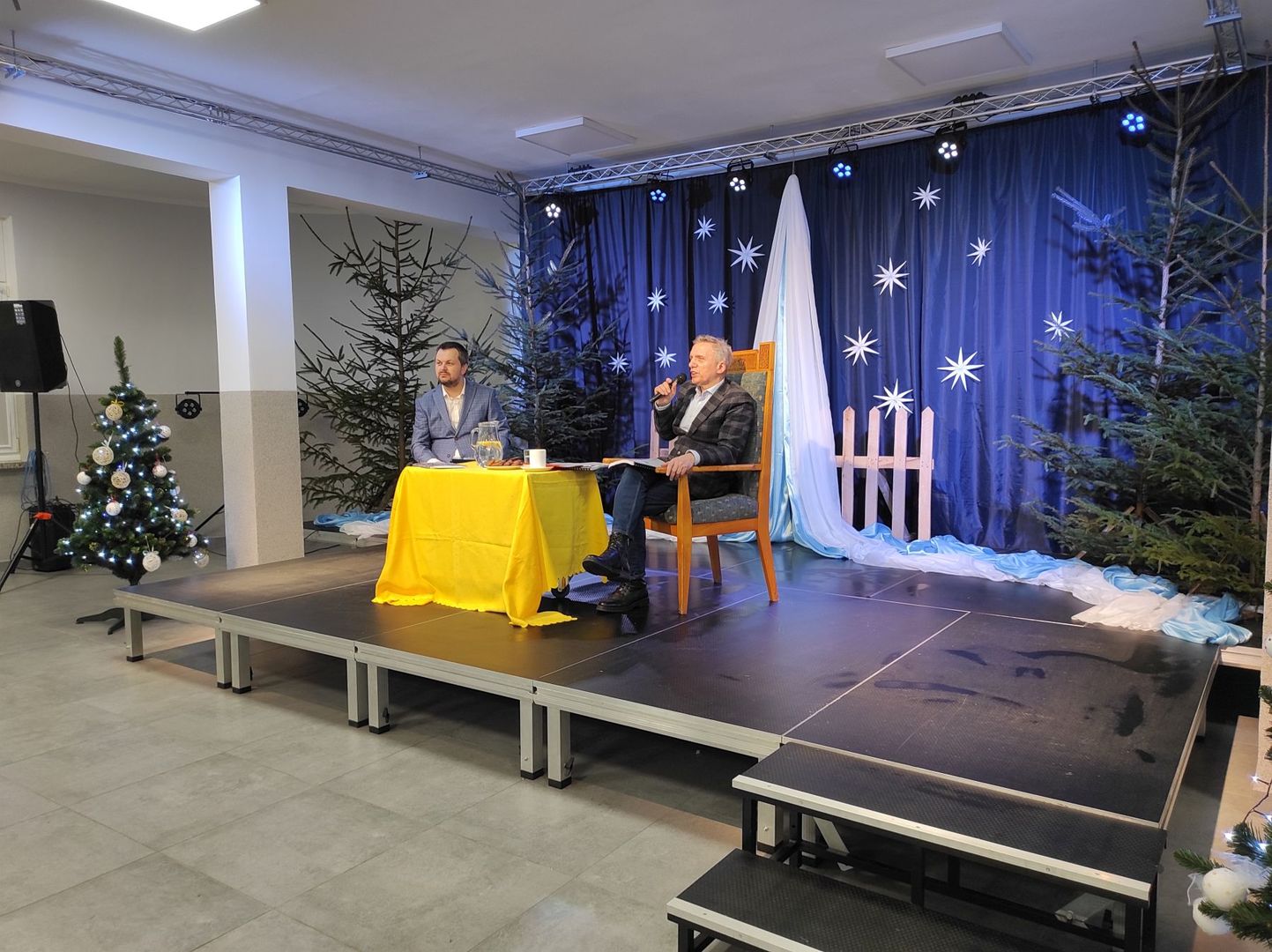 Prowadzący spotkanie i producent Paweł Strojek na scenie Świetlicy Kultury w Malechowie. 