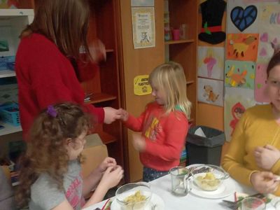 Dzieci z Placówki Wsparcia Dziennego z Lasek łamią się opłatkiem. 