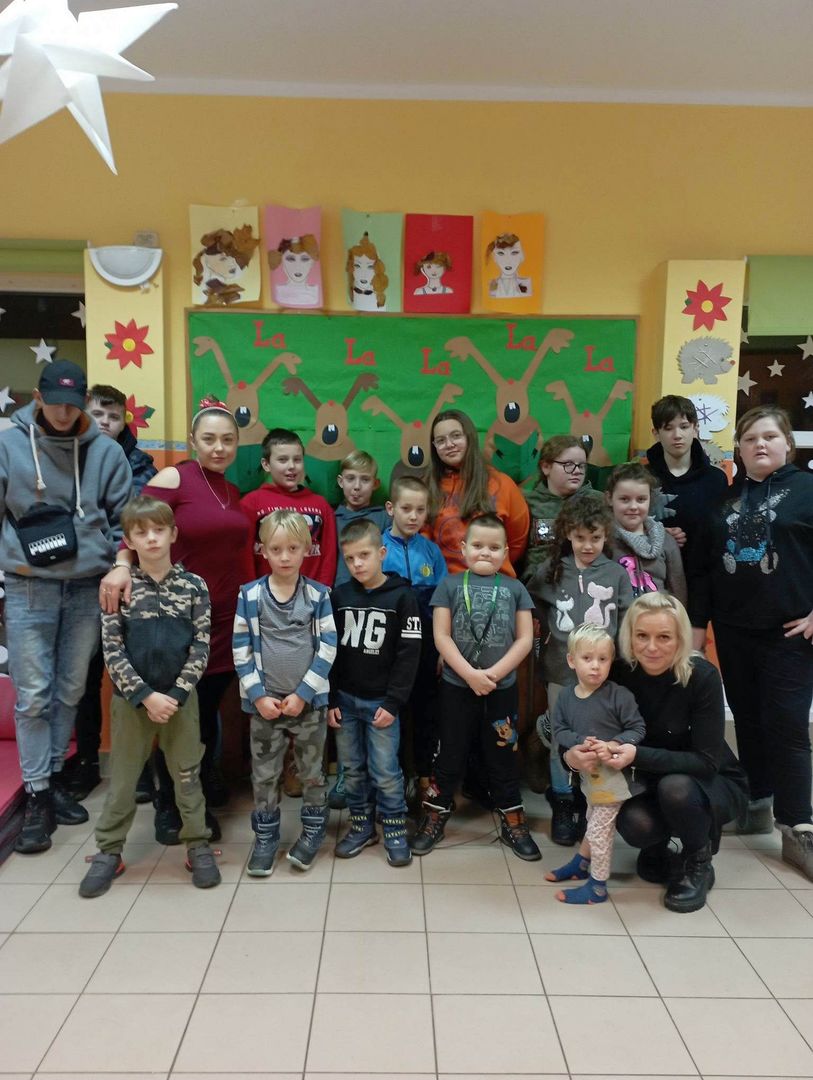 Dzieci z Placówki Wsparcia Dziennego z Lasek wraz z wychowawczyniami pozują do grupowego zdjęcia. 