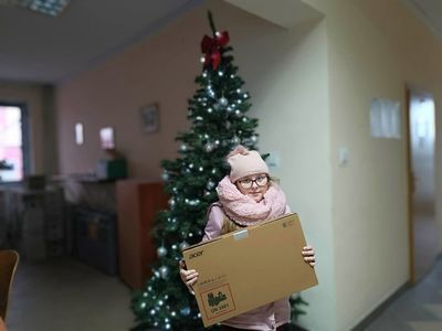 Dziewczynka pozuje z laptopem przy choince w malechowskim Urzędzie. 