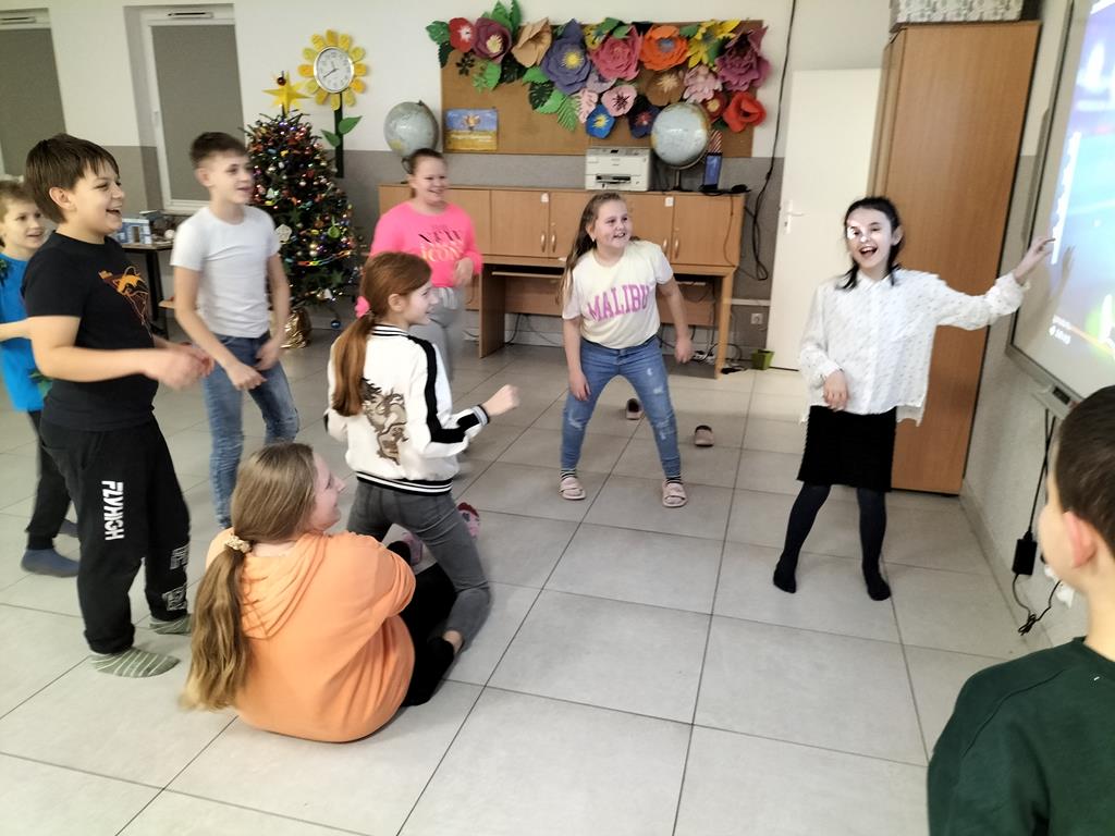Dzieci z Placówki Wsparcia Dziennego w Kusicach przy ekranie multimedialnym.