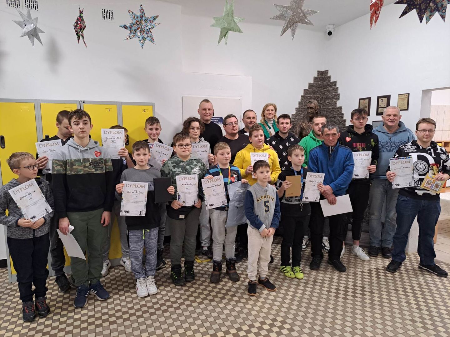 Zdjęcie przedstawia wszystkich wszystkich zawodników turnieju wraz z dyplomami oraz nagrodami, dyrektor SP Lejkowo oraz sędziego.