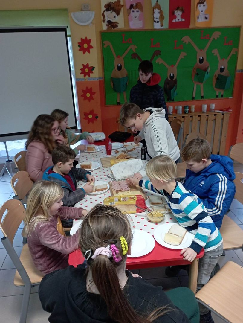 Dzieci przygotowujące tosty na zajęciach kulinarnych.