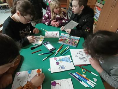 Wychowankowie z PWD z Lasek wykonują upominki mazakami i farbami na deseczce dla najbliższych.