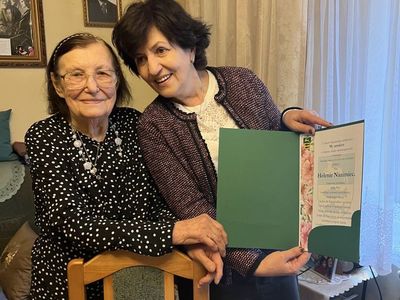 Jubilatka z córką prezentują list gratulacyjny.