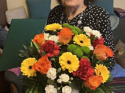 Jubilatka Helena Nazimiec z bukietem kwiatów.