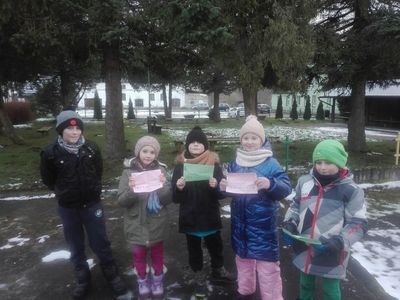 Dzieci z PWD w Podgórkach, przed wyjściem do lasu  przedstawiają kartki z tropami zwierząt.
