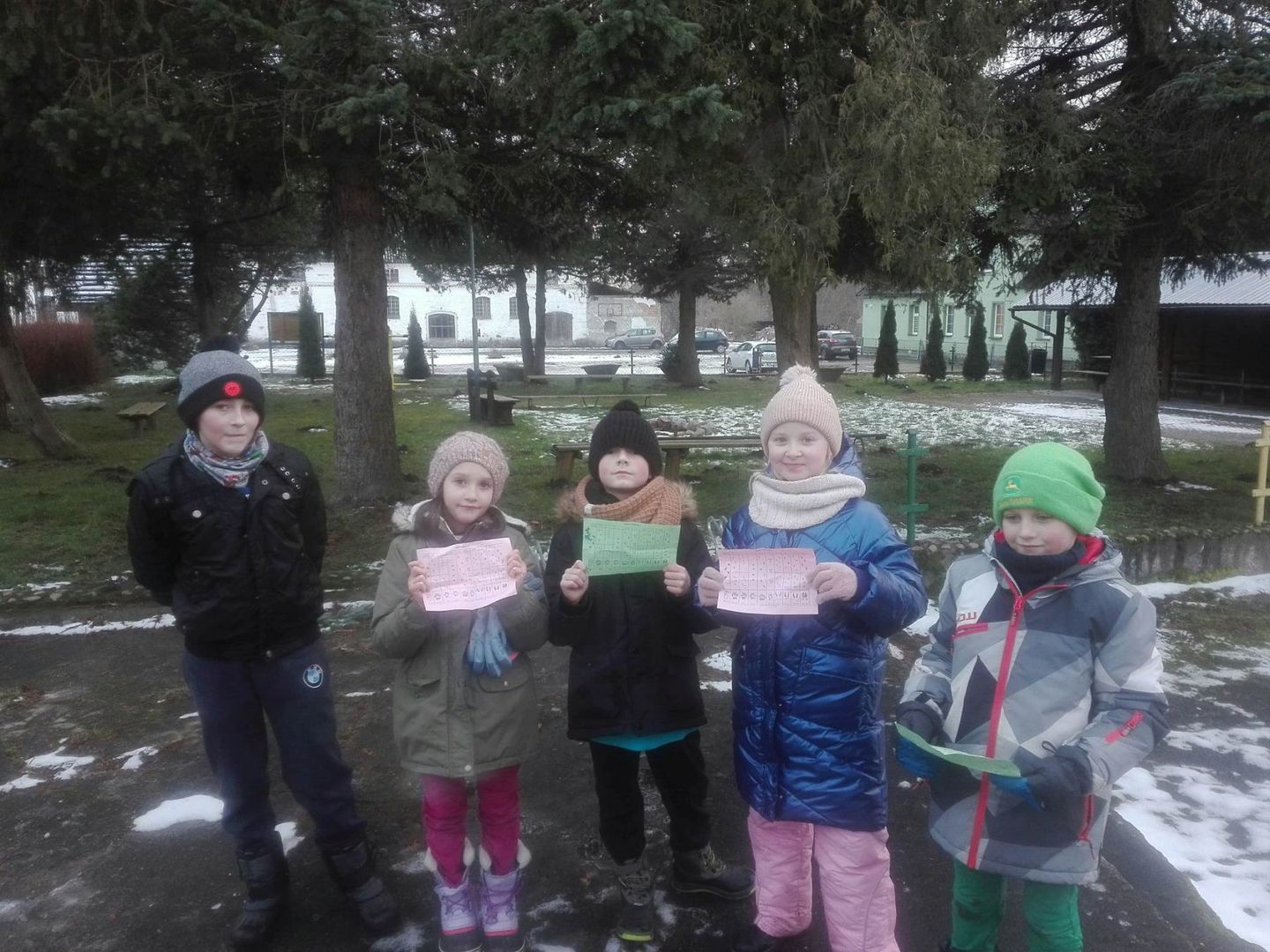 Dzieci z PWD w Podgórkach, przed wyjściem do lasu przedstawiają kartki z tropami zwierząt.