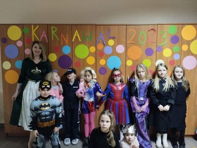 Dzieci z PWD wraz z wychowawczynią prezentują stroje karnawałowe.