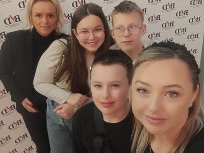 Dzieci z PWD z Lasek wraz z wychowawczyniami pozują do zdjęcia w teatrze.