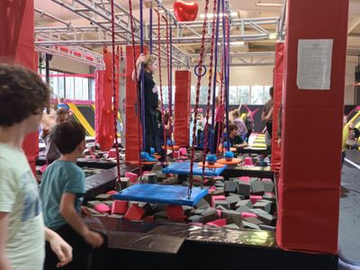 Pokonywanie przeszkód przez dzieci w parku trampolin.
