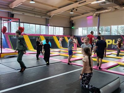 Dzieci skaczą na trampolinach.