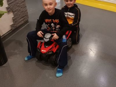 Dwóch chłopców jeździ na samochodach w parku trampolin.
