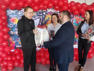 Wójt Radosław Nowakowski przekazuje gratulacje Arturowi Beśce, obok wolontariuszka Beata Hetmańska i szefowa Sztabu WOŚP Gminy Malechowo -  Eliza Wróblewska-Hencel.