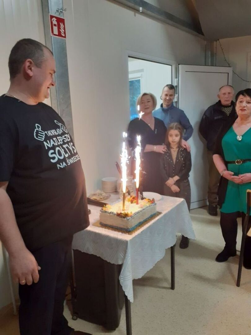 Sołtys oraz uczestnicy spotkania wraz z tortem.