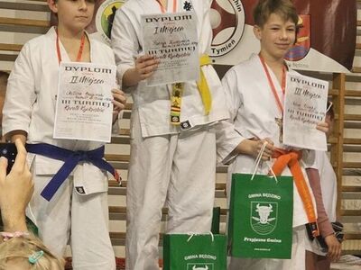 Zawodnicy z nagrodami i pucharami na podium.