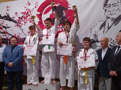 Bartłomiej Podbereżny na podium prezentuje puchar.