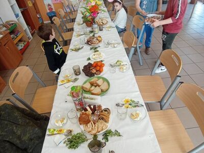 Wychowankowie z PWD Laski dekorują wielkanocny stół.