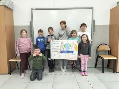 Zdjęcie przedstawia dzieci podczas pracy przy plakacie dla pracowników służby zdrowia.