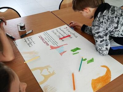 Zdjęcie przedstawia dzieci podczas pracy przy plakacie dla pracowników służby zdrowia.