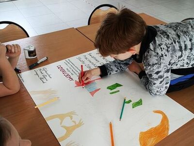 Zdjęcie przedstawia dzieci podczas pracy przy plakacie dla pracowników służby zdrowia.
