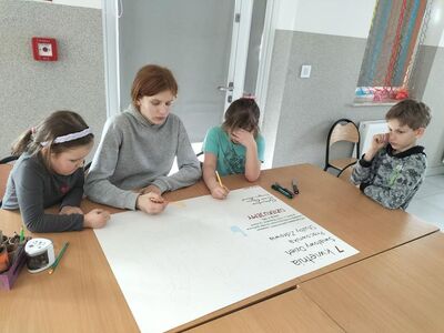 Dzieci podczas pracy przy plakacie dla pracowników służby zdrowia.