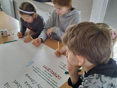 Zdjęcie przedstawia dzieci podczas pracy przy plakacie dla pracowników służby zdrowia.