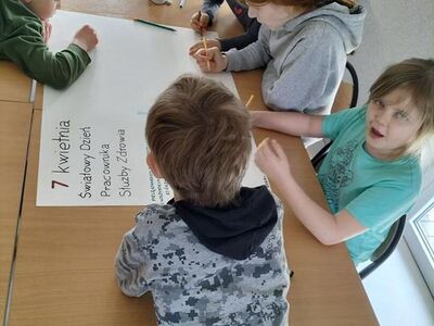 Dzieci tworzą plakat z podziękowaniami dla pracowników służby zdrowia.