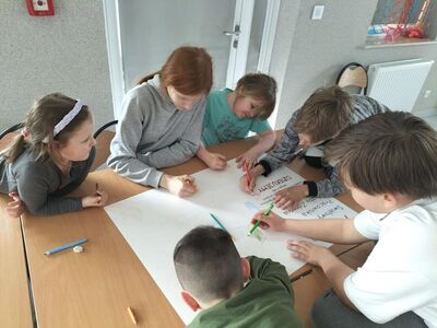 Zdjęcie przedstawia dzieci podczas pracy przy plakacie dla pracowników służby zdrowia.