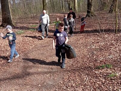 Wychowankowie z PWD z Lasek sprzątają park z okazji Dnia Ziemi.