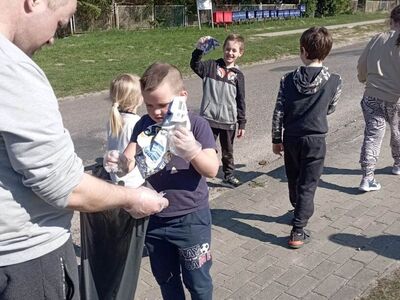 Wychowankowie z PWD sprzątają miejscowość z okazji Dnia Ziemi.