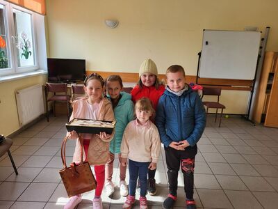 Dzieci pozują do zdjęcia z przygotowanym ciastem.