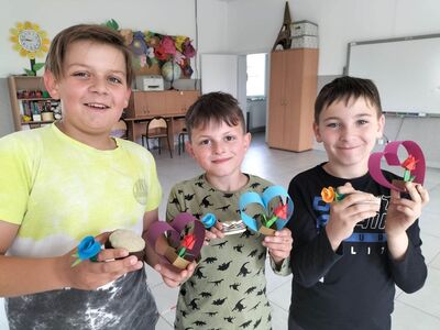 Dzieci prezentują wykonane papierowe serduszka z tulipanem origami.