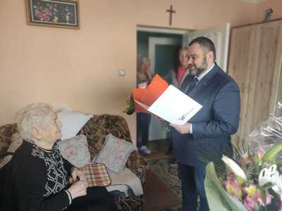 Wójt Radosław Nowakowski wręcza kwiaty Pani Marii Kolarz. 