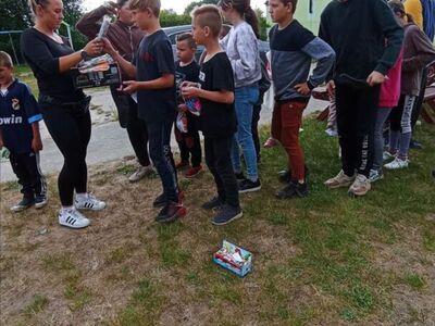 Dzieci z PWD z Lasek odbierają lody oraz nagrody wylosowane w loterii fantowej.