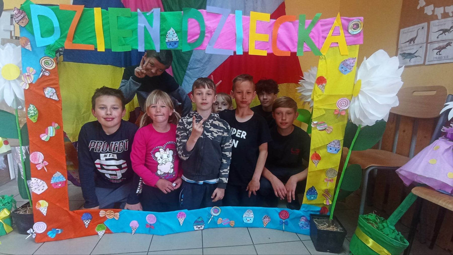 Dzieci z PWD z Lasek pozują do zdjęcia w kolorowej fotobudce.