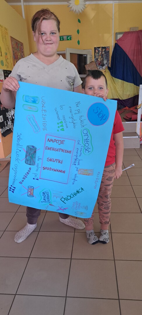 Podopieczni prezentują wspólnie wykonany plakat.