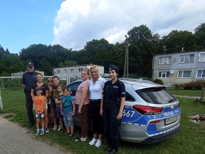 Dzieci z PWD z Lasek pozują do zdjęcia wraz z Policjantami i wychowawczyniami.