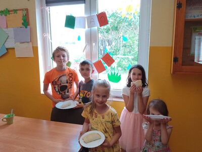 Dzieci prezentują na talerzach wykonane calzone.