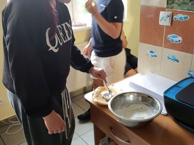 Dziewczynka smaruje naleśnika nadzieniem.