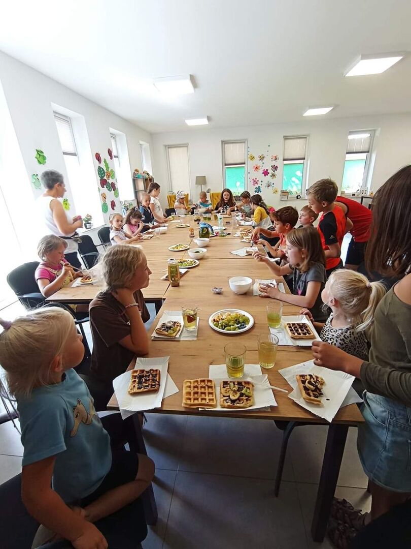 Dzieci z obu świetlic degustują upieczone gofry z dodatkami.